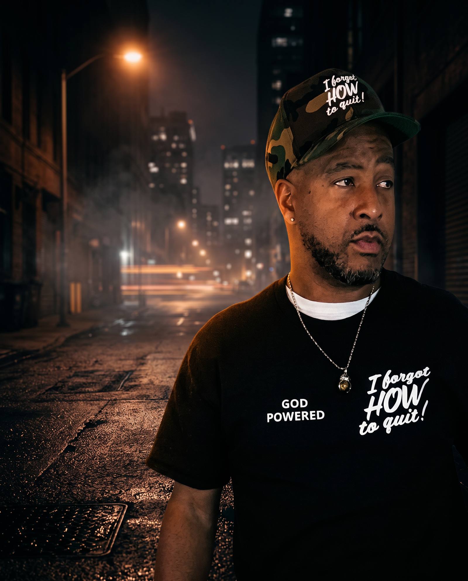 Founder of I Forgot How to Quit in a camo cap and God Powered tee on a dark city street at night